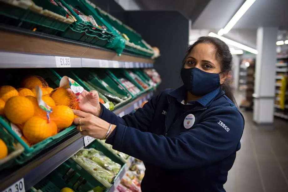 image of a worker in tesco shelving fruit