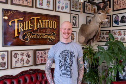 An image of a man with tattoos inside True Tattoo parlor