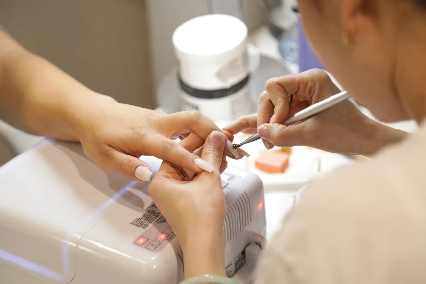 image of a nail technician doing a manicure on a client