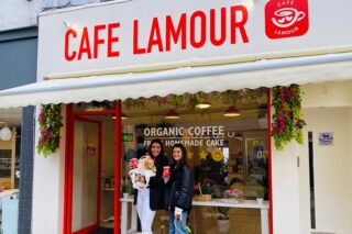 Photo of front of Cafe lamour with two girls and a dog