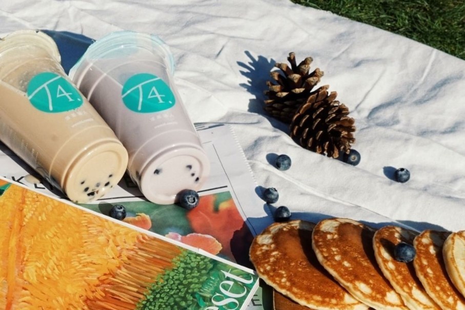 Bubble tea with magazine and acorn on a blanket