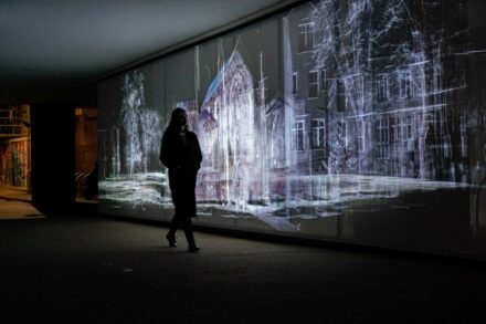 woman walking in front of echolocation public artwork video projection