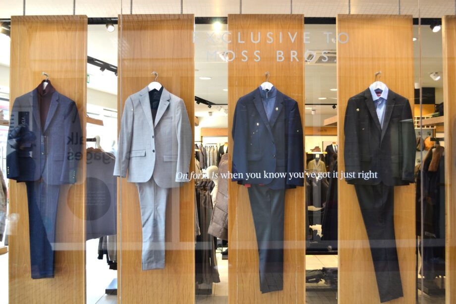 An image of a shop front with suits