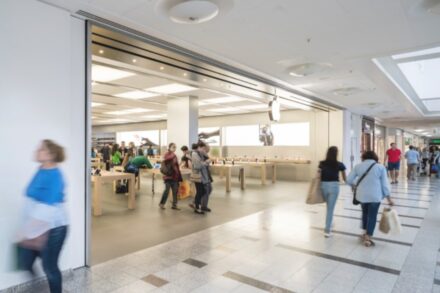 images of people walking in front of the Apple Store