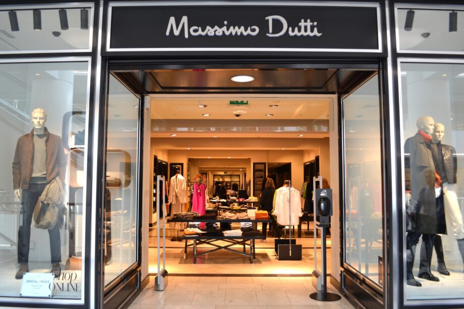 Image of front of Massimo Dutti store with branding and shoppers outside