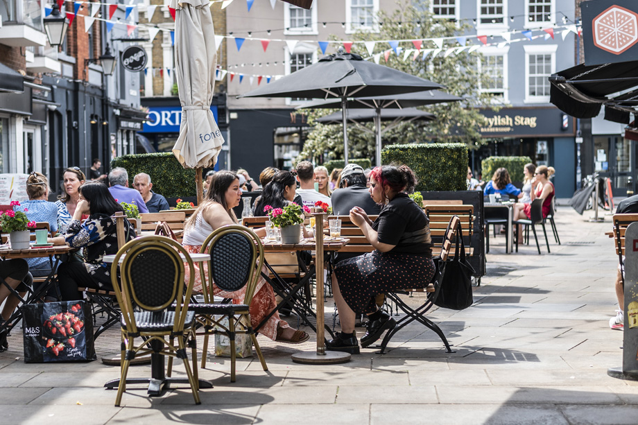 Alfresco diners sit at tables enjoying food and drinks